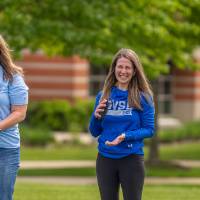Two players smile and laugh holding bags